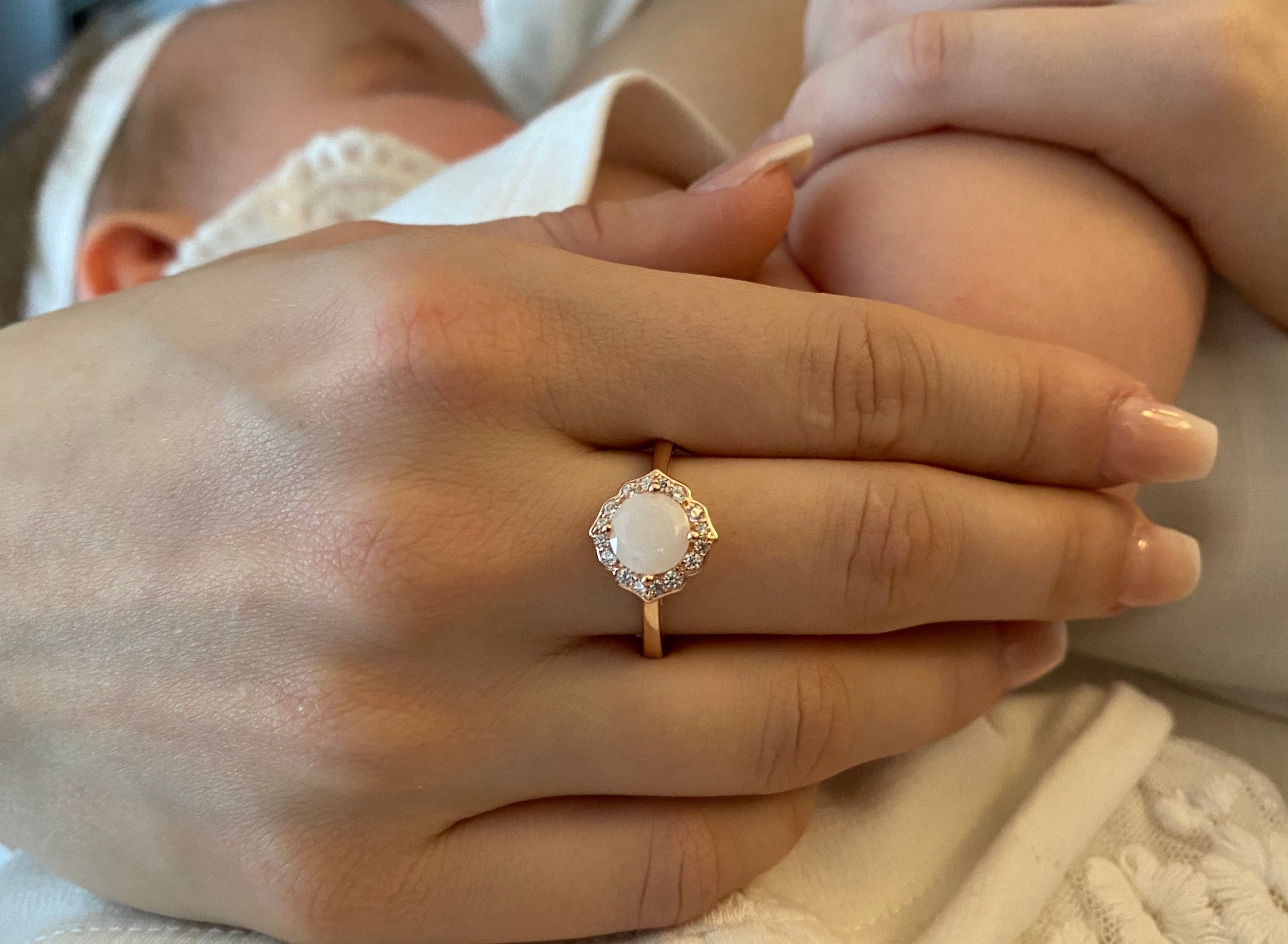 Close up of Mother's Hand Wearing Breast Milk Ring While Holding Baby - KeepsakeMom