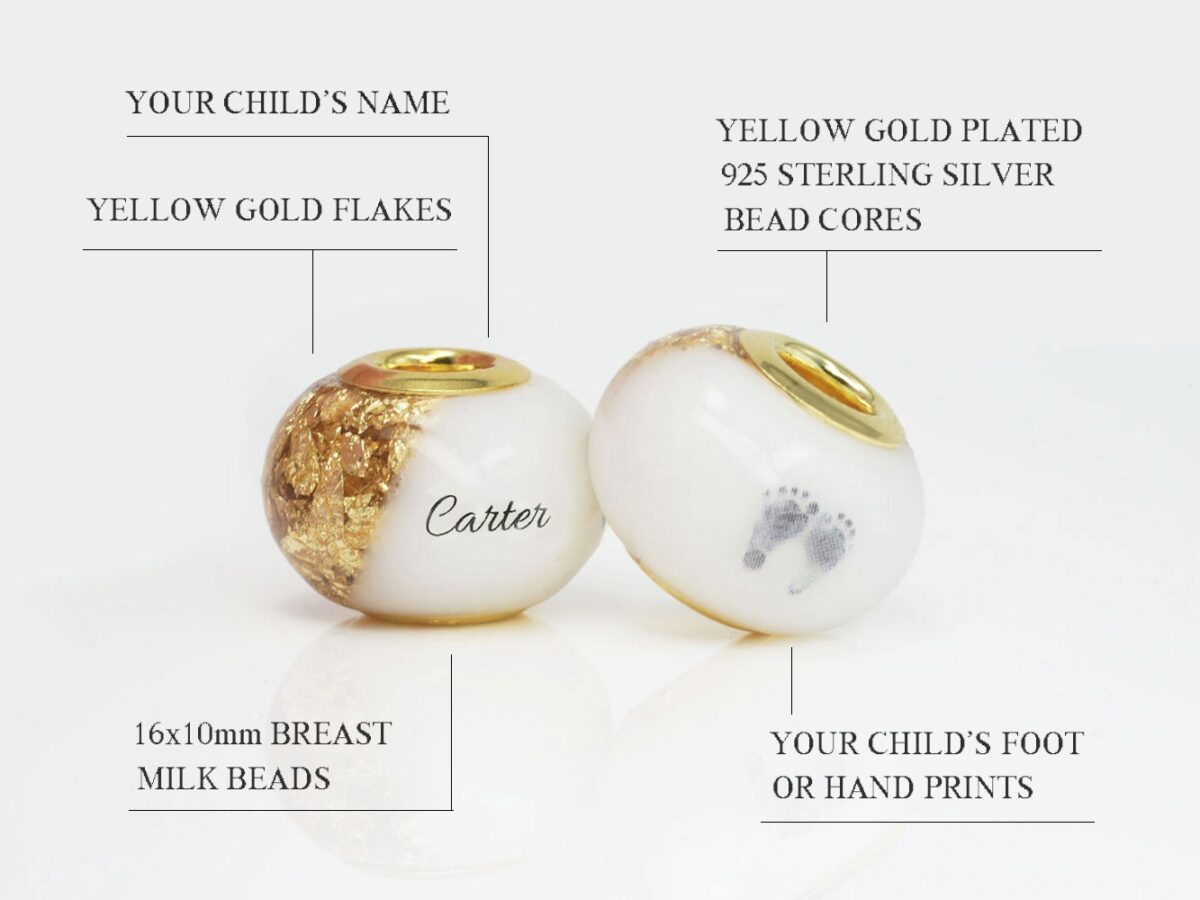 two breast milk beads with yellow gold flakes on the sides and name and baby foot prints in the milk portion with yellow gold bead cores diagram describing features from keepsakemom