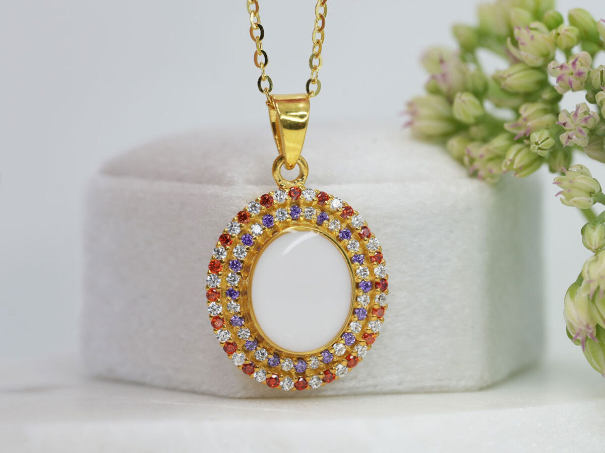 breastrmilk jewelry oval necklace with double halo of birth month color crystals from KeepsakeMom in yellow gold with clear, red and purple alternating