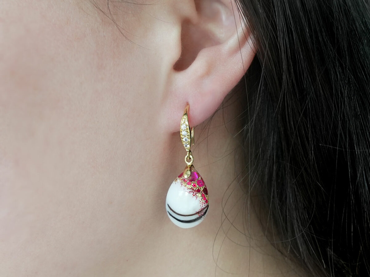 breastmilk jewelry earrings on a model ear from KeepsakeMom fancy dangle drop with red flakes and baby hair