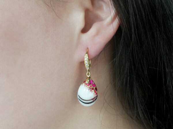 breastmilk jewelry earrings on a model ear from KeepsakeMom fancy dangle drop with red flakes and baby hair