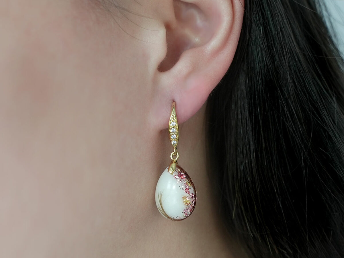 breastmilk jewelry earrings on a model ear from KeepsakeMom fancy dangle drop with shimmers and pink flakes