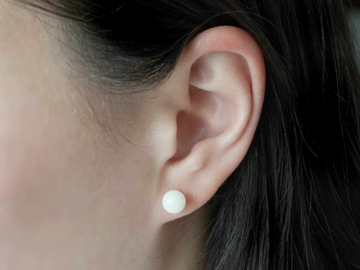 breastmilk jewelry earrings on a model ear from KeepsakeMom simple pearl studded