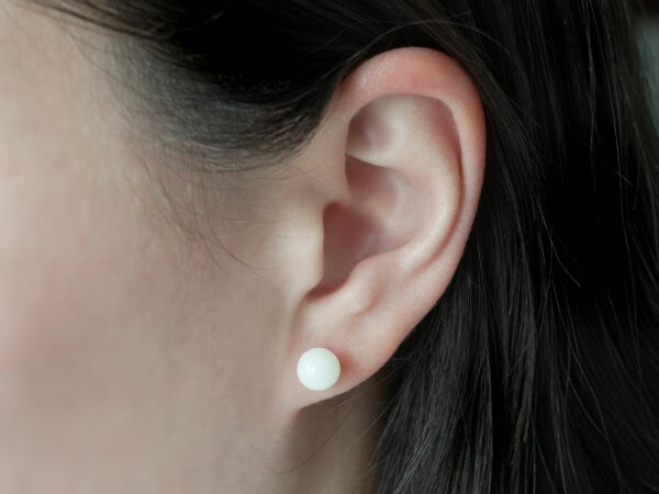 breastmilk jewelry earrings on a model ear from KeepsakeMom simple pearl studded