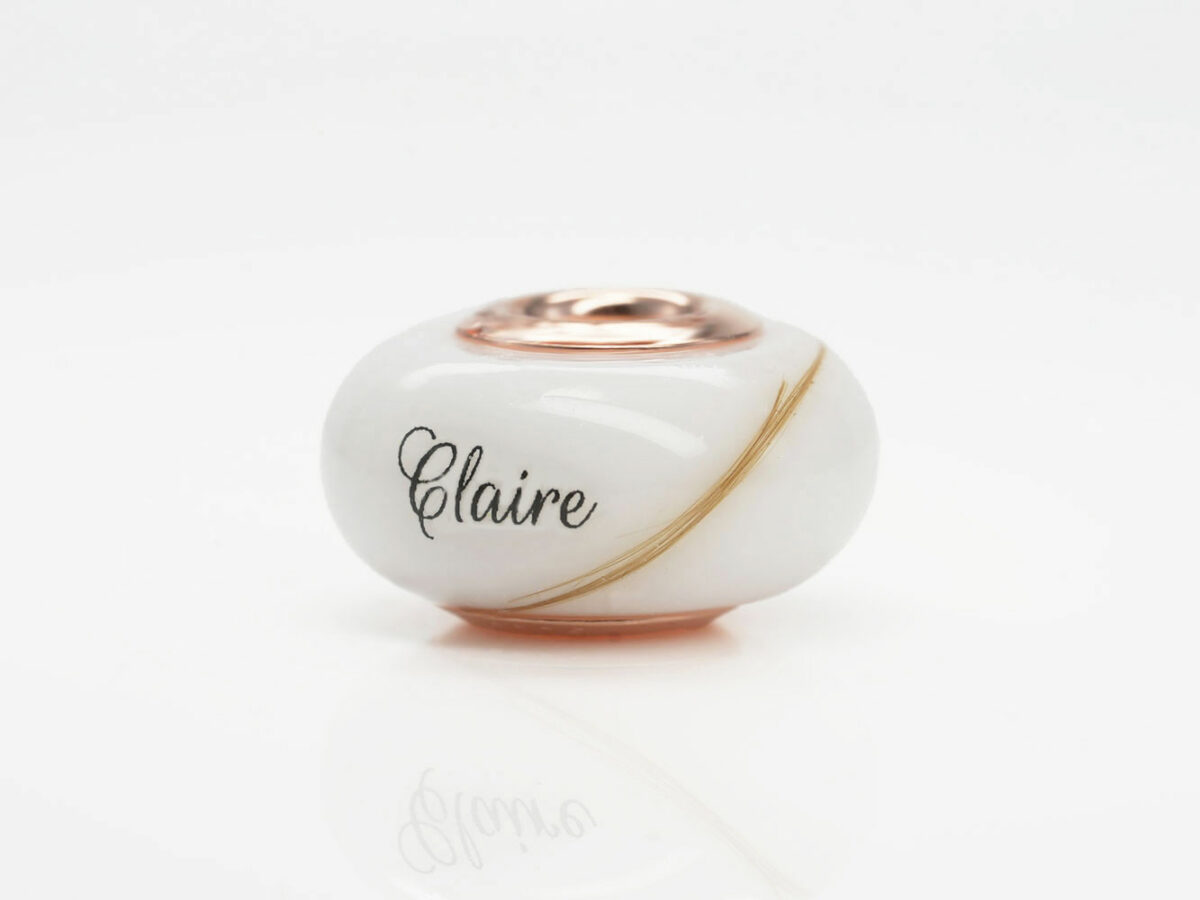 breast milk bead chubby with lock of hair and name with rose gold cores on a white background from keepsakemom