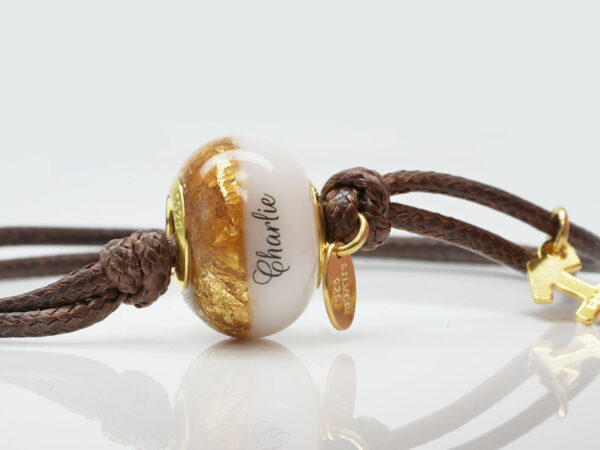 breastmilk one bead bracelet with birth month colors of citrine with gold flakes, and name on the breastmilk part of the bead on a waxed brown cord on white background from KeepsakeMom close-up