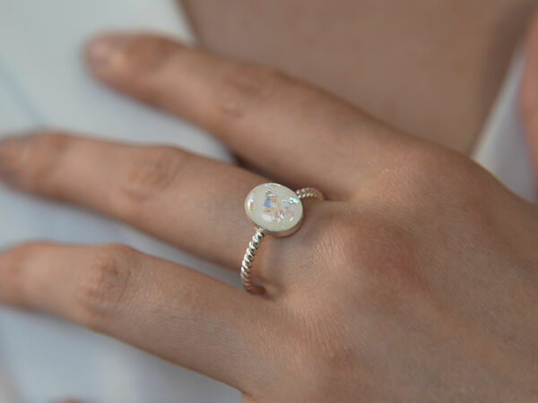 breastmilk jewelry oval ring KeepsakeMom silver opal flakes model hand