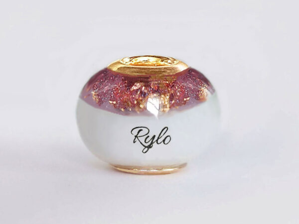 breastmilk bead with birth month color purple with gold flakes at the top and child's name in the milk engraved with gold cores from KeepsakeMom on white background