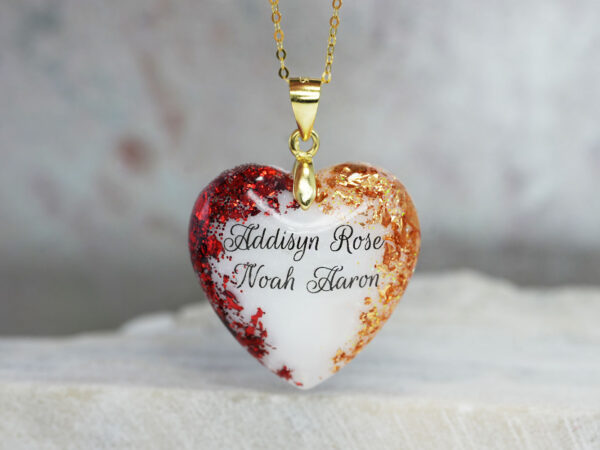 Breastmilk jewelry heart necklace celebrating two children with garnet red and november citrine yellow flakes, names, and gold chain and bail from KeepsakeMom