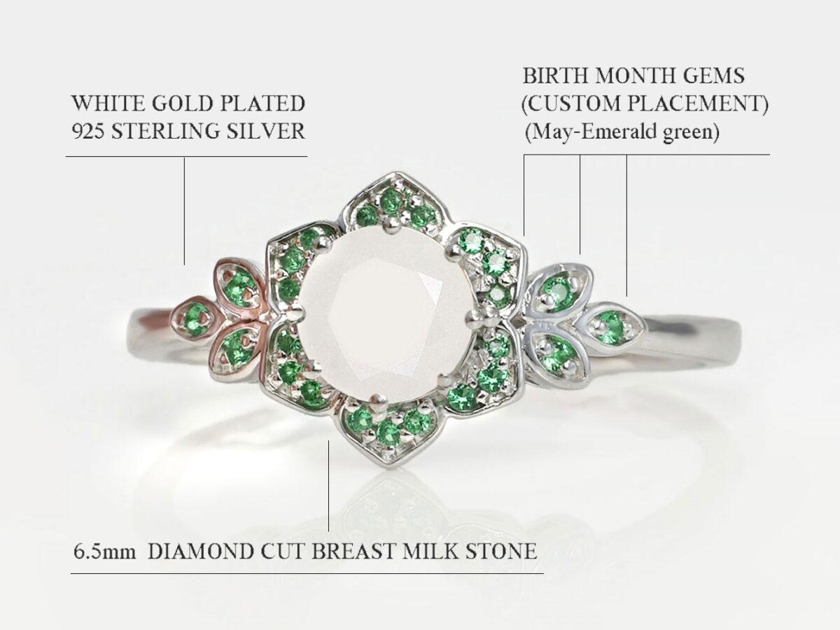 breastmilk sterling silver ring white gold plated flower shaped with central breastmilk stone diamond faceted shaped with opal flakes and leaves in green gems emerald diagram describing features on white background from keepsakemom
