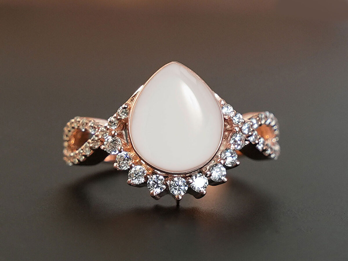 breastmilk jewelry ring clear crystals around teardrop from KeepsakeMom rose gold on brown background