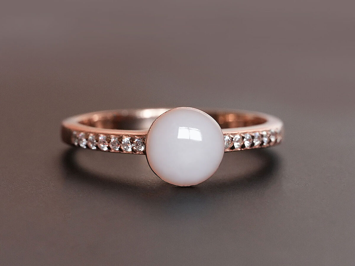 breastmilk ring in rose gold with round breastmilk stone and side crystals on brown background from keepsakemom
