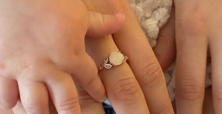 Mother and baby’s hands with birthstone jewelry