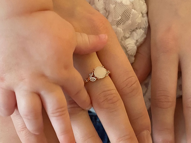 Mother and baby’s hands with birthstone jewelry