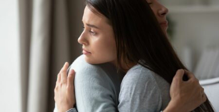 A grieving young mother holding her mother