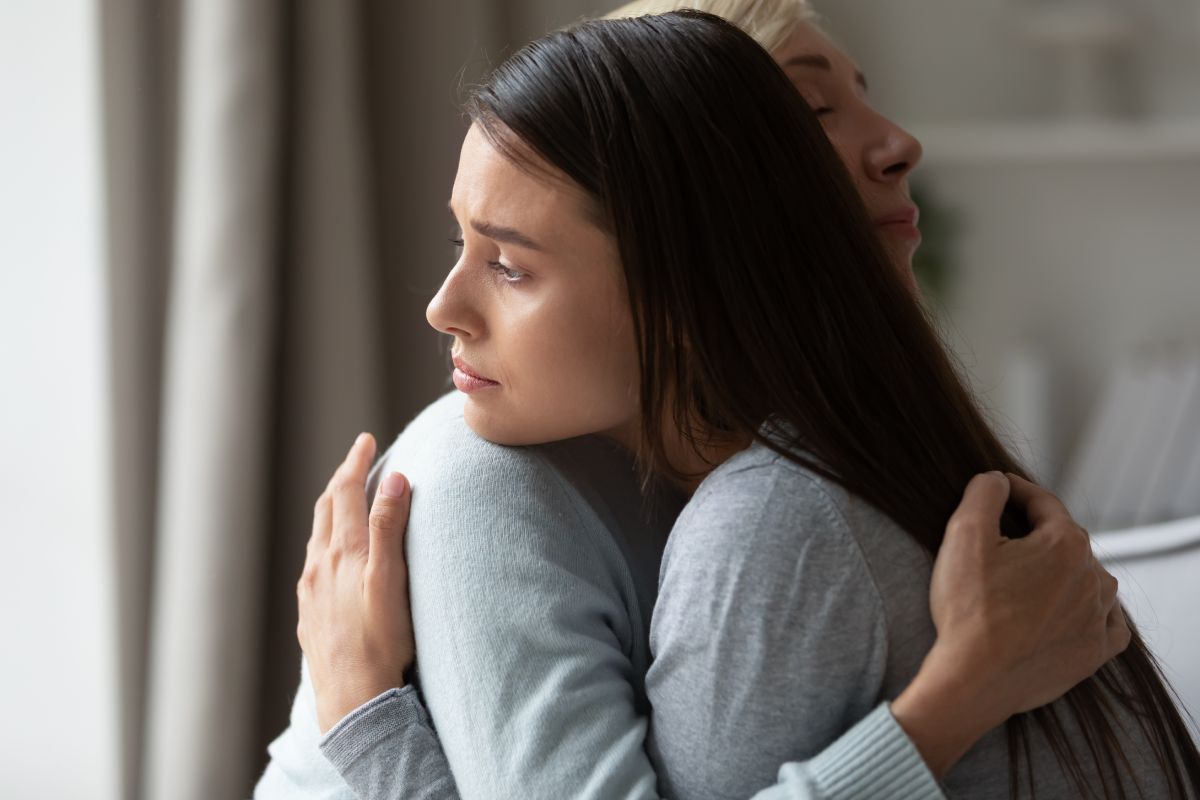 A grieving young mother holding her mother