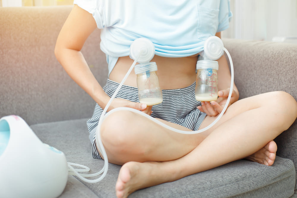 Mother using an electric breast pump