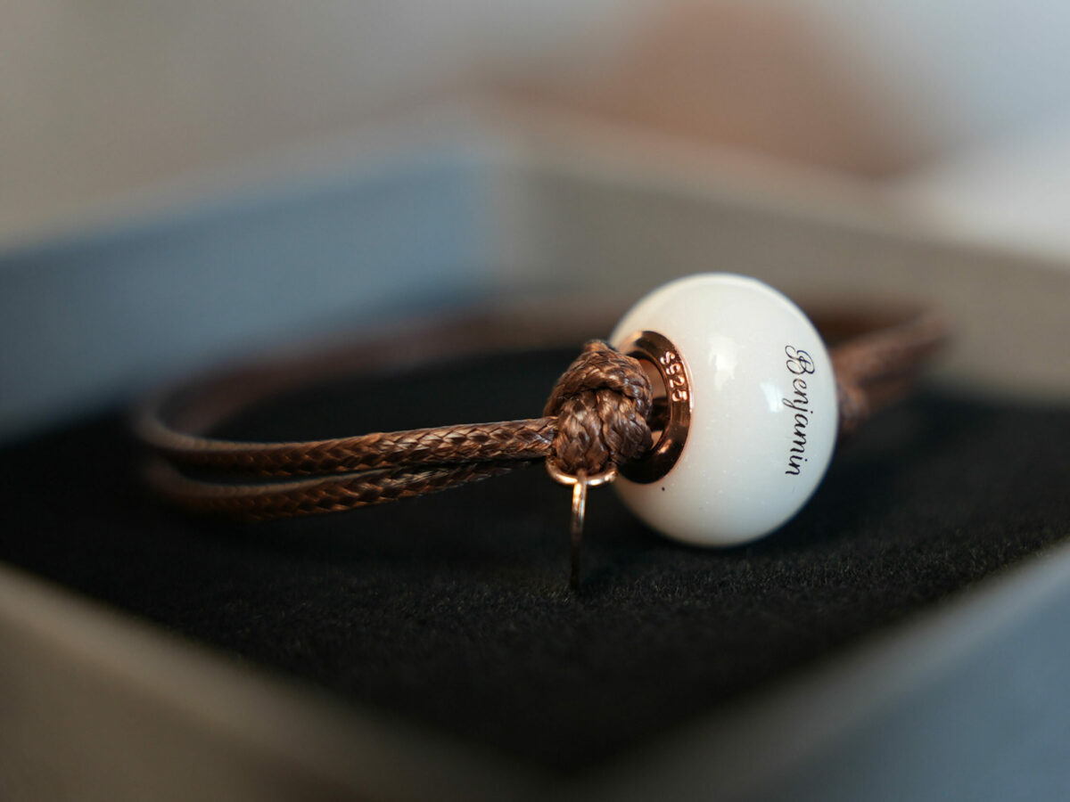 breastmilk jewelry bead brown cord bracelet with rose gold bead cores and tag with child's name on the bead engraved from KeepsakeMom in a box