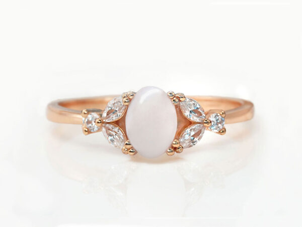 breast milk ring with oval stone with three clear crystals or diamonds on each side in rose gold setting from KeepsakeMom