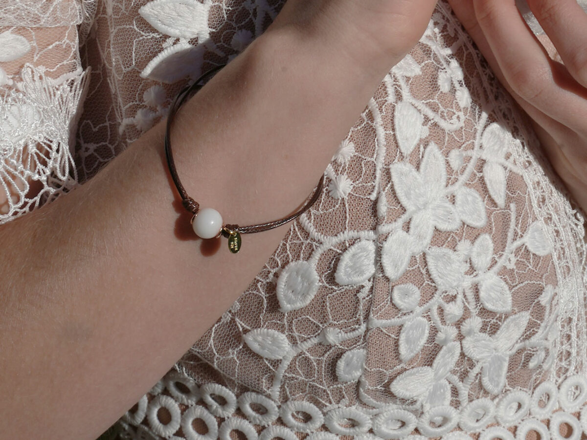 breastmilk jewelry model in white dress wearing bracelet from KeepsakeMom