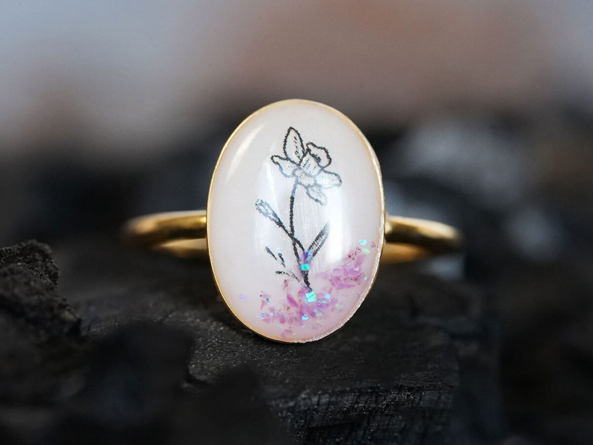 breast milk ring oval shaped with flower outline in the milk stone with purple gems from keepsakemom