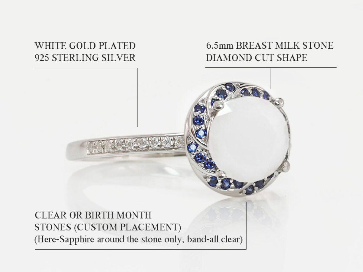 breast milk ring white gold on a white background with sapphire blue gems around milk stone halo