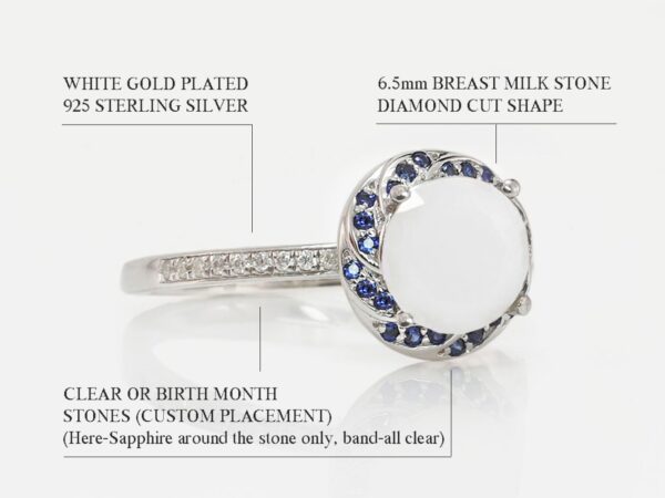 breast milk ring white gold on a white background with sapphire blue gems around milk stone halo