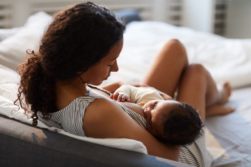 Mother breastfeeding her baby in bed