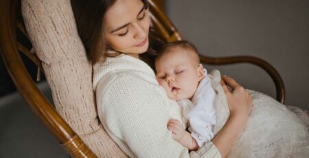 Mom and baby asleep in rocking chair