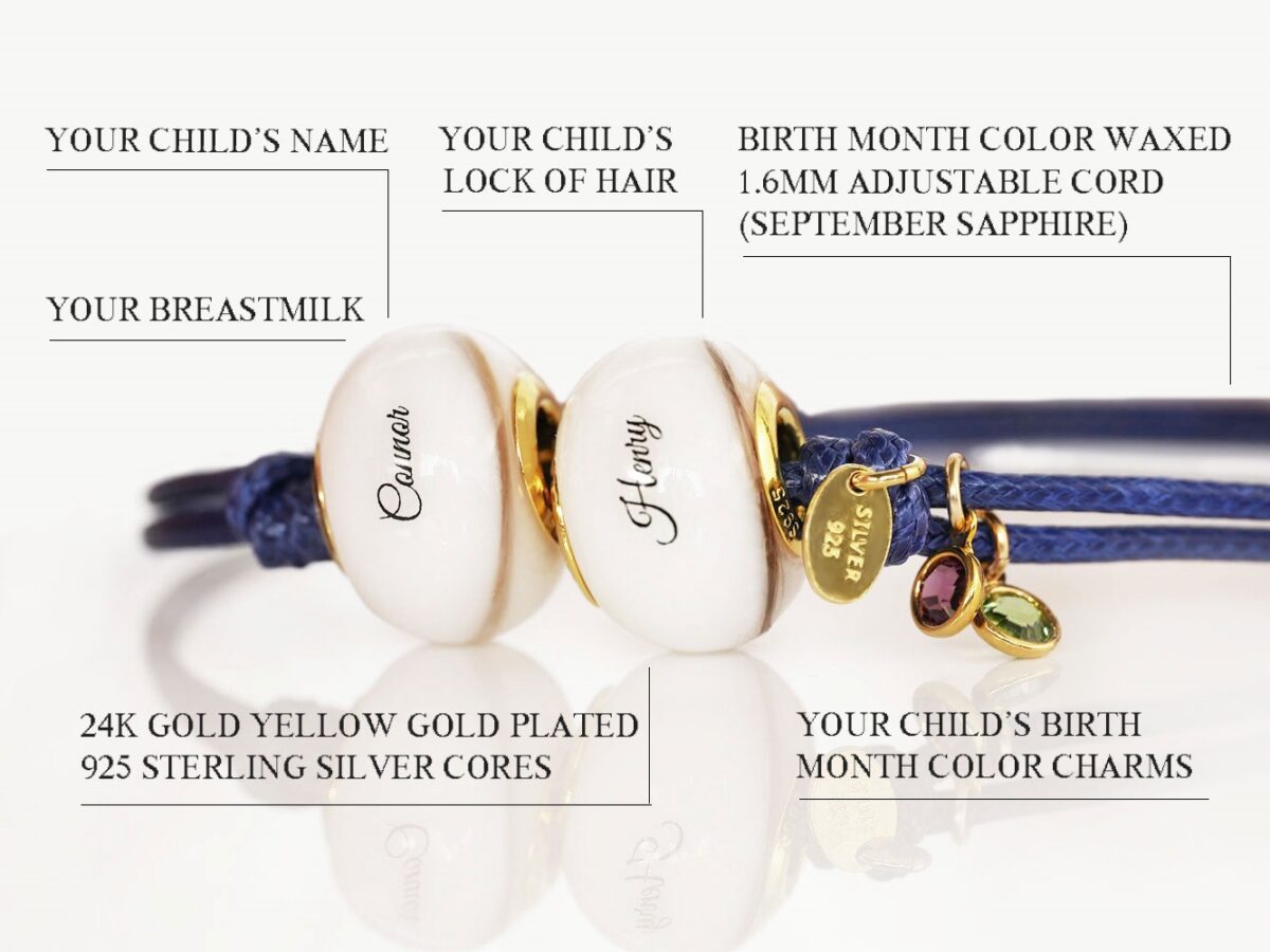breast milk jewelry bracelet on a white background with two beads made with breastmilk with children's names, locks of hair and with navy blue cord and gold birth month charms from KeepsakeMom