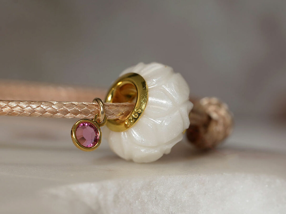 breastmilk jewelry flower bead bracelet with yellow gold bead cores and pink birth charm pearl powder from keepsakemom