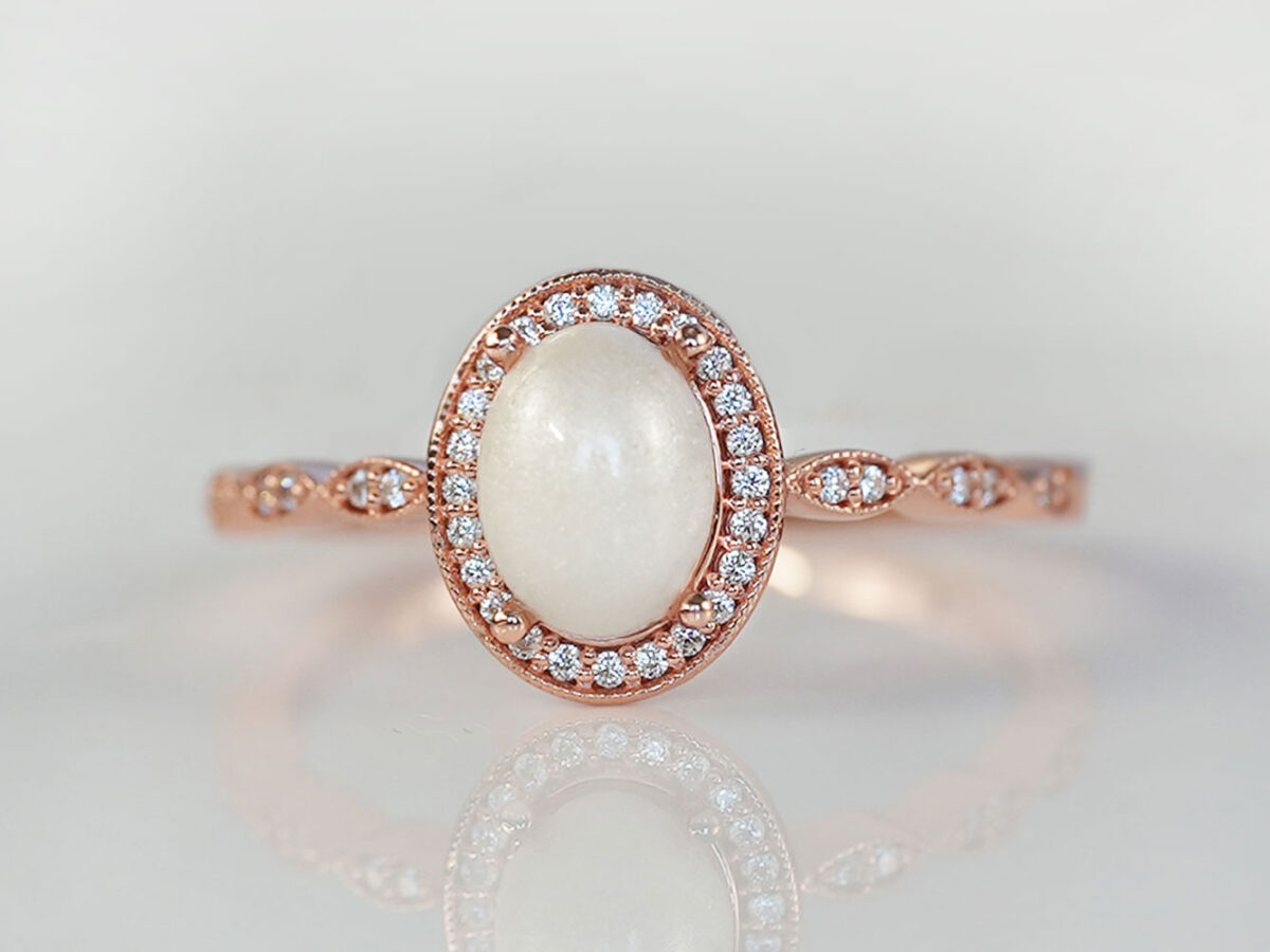 breastmilk jewelry ring oval stone fine band with crystals around the stone and the band fine ring rose gold KeepsakeMom pearl powder added to the stone