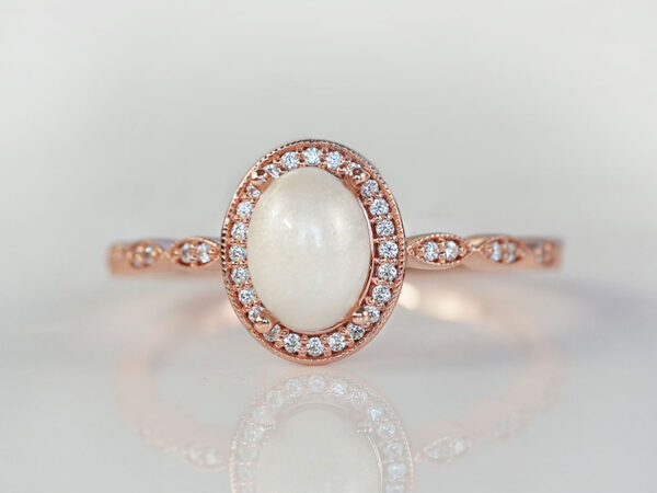 breastmilk jewelry ring oval stone fine band with crystals around the stone and the band fine ring rose gold KeepsakeMom pearl powder added to the stone