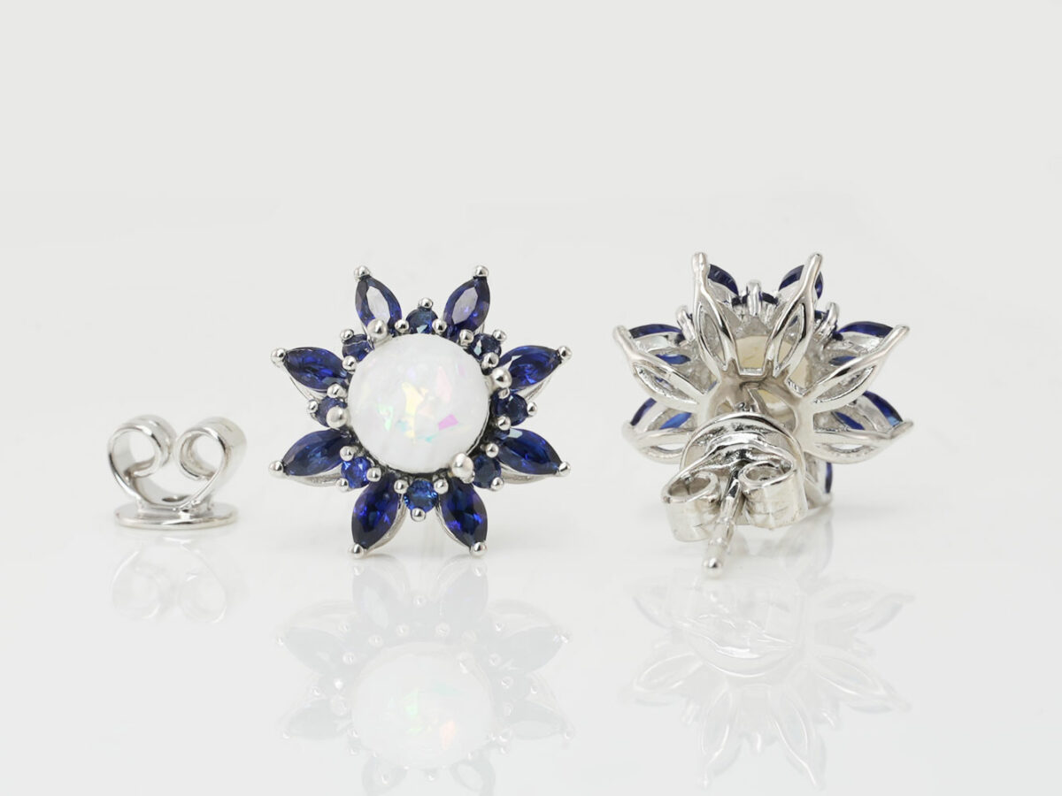 breastmilk jewelry fancy star or flower shaped studded earrings with birth month colored gems sapphire blue as leaves from KeepsakeMom on white background shown from the back and front
