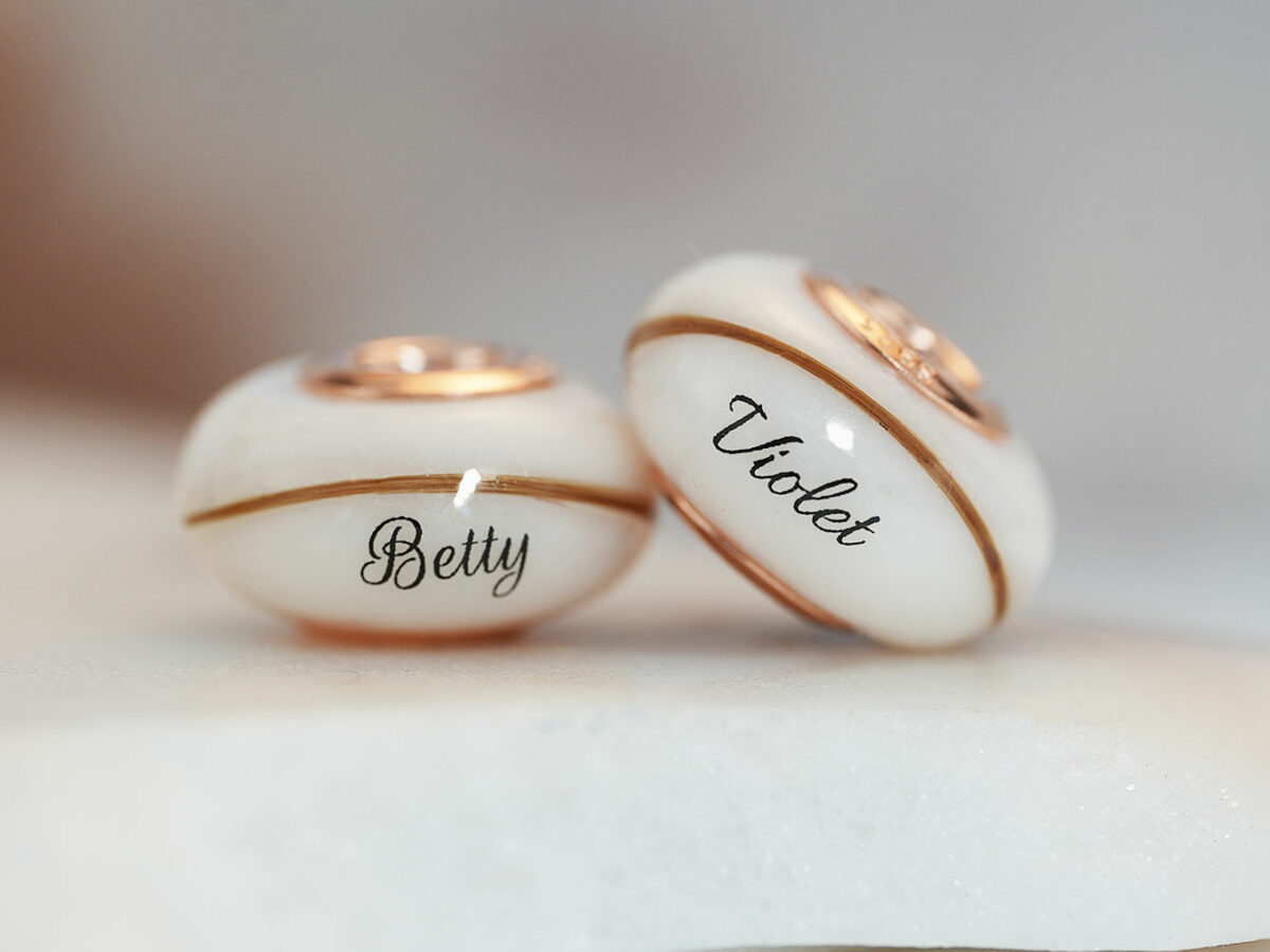 two breastmilk beads with rose gold bead cores with hair and child's name birth date from KeepsakeMom