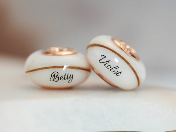 two breastmilk beads with rose gold bead cores with hair and child's name birth date from KeepsakeMom