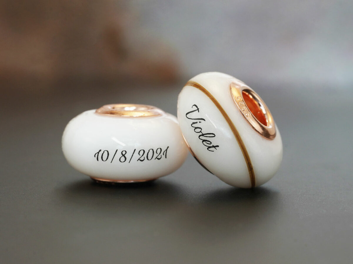 two breastmilk beads with rose gold bead cores with hair and child's name birth date from KeepsakeMom