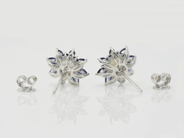 breastmilk jewelry fancy star or flower shaped studded earrings with birth month colored gems sapphire blue as leaves from KeepsakeMom on white background shown from the back