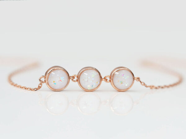 breastmilk jewelry luna three small discs bracelet rose gold setting from keepsakemom on white background with opal flakes