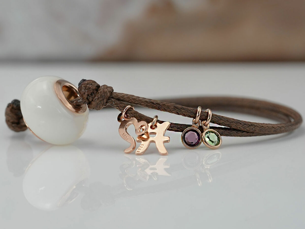 breastmilk jewelry bead brown cord bracelet with rose gold bead cores and charms zodiacs and birth color purple and green from KeepsakeMom