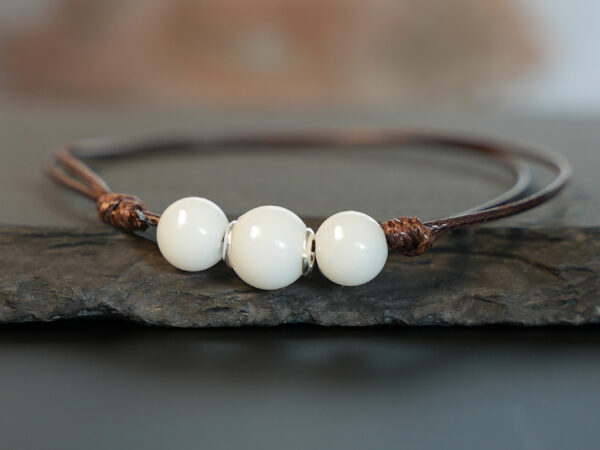 breastmilk three simple pearl made with breastmilk on a brown cord with silver cores on brown background from keepsakemom