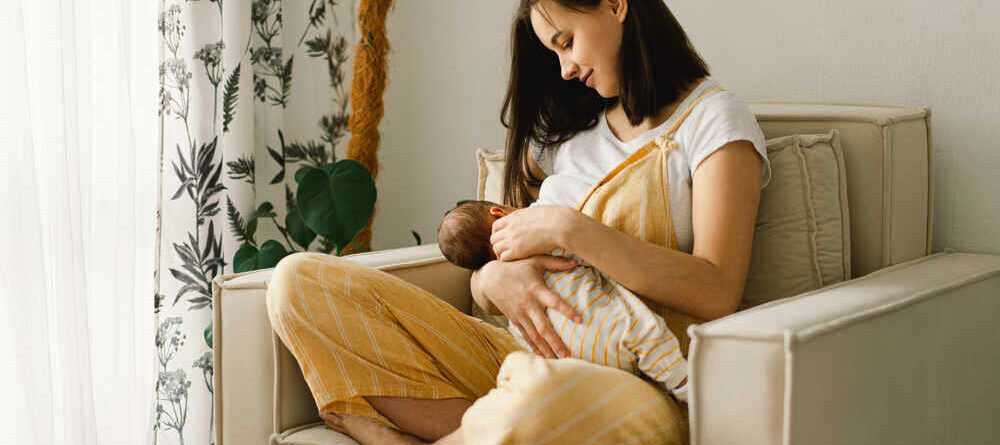 Portrait of mom and breastfeeding baby in living room