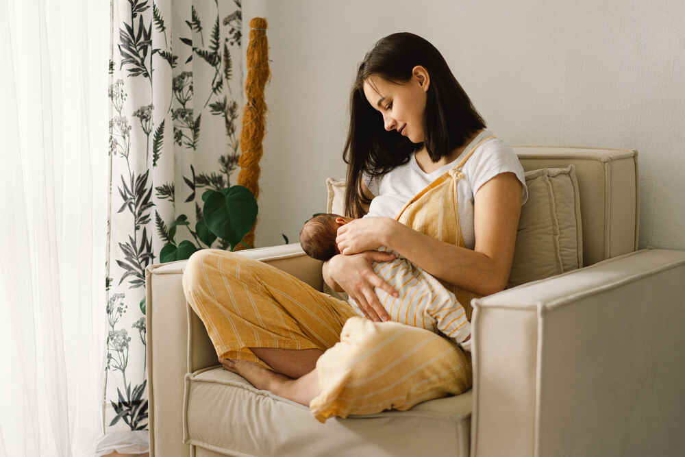 Portrait of mom and breastfeeding baby in living room
