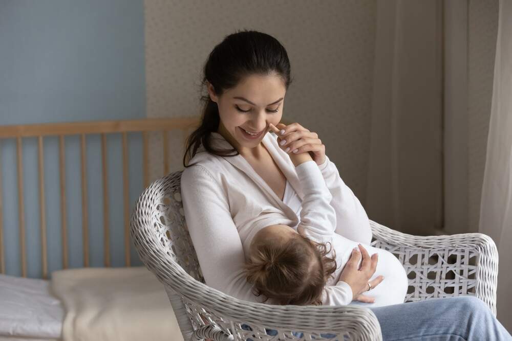 Happy young mom enjoying breastfeeding baby