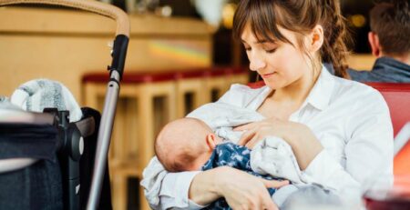 Young mother breastfeeding in public