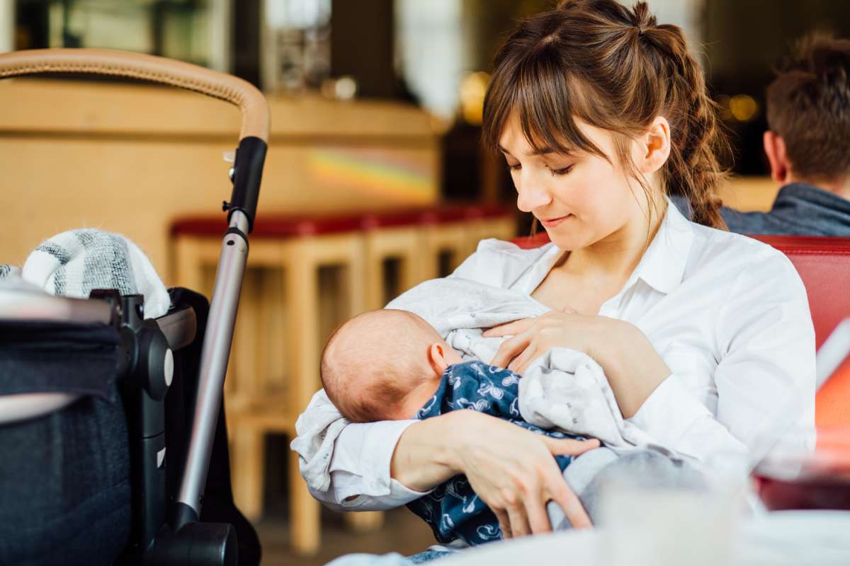 Young mother breastfeeding in public