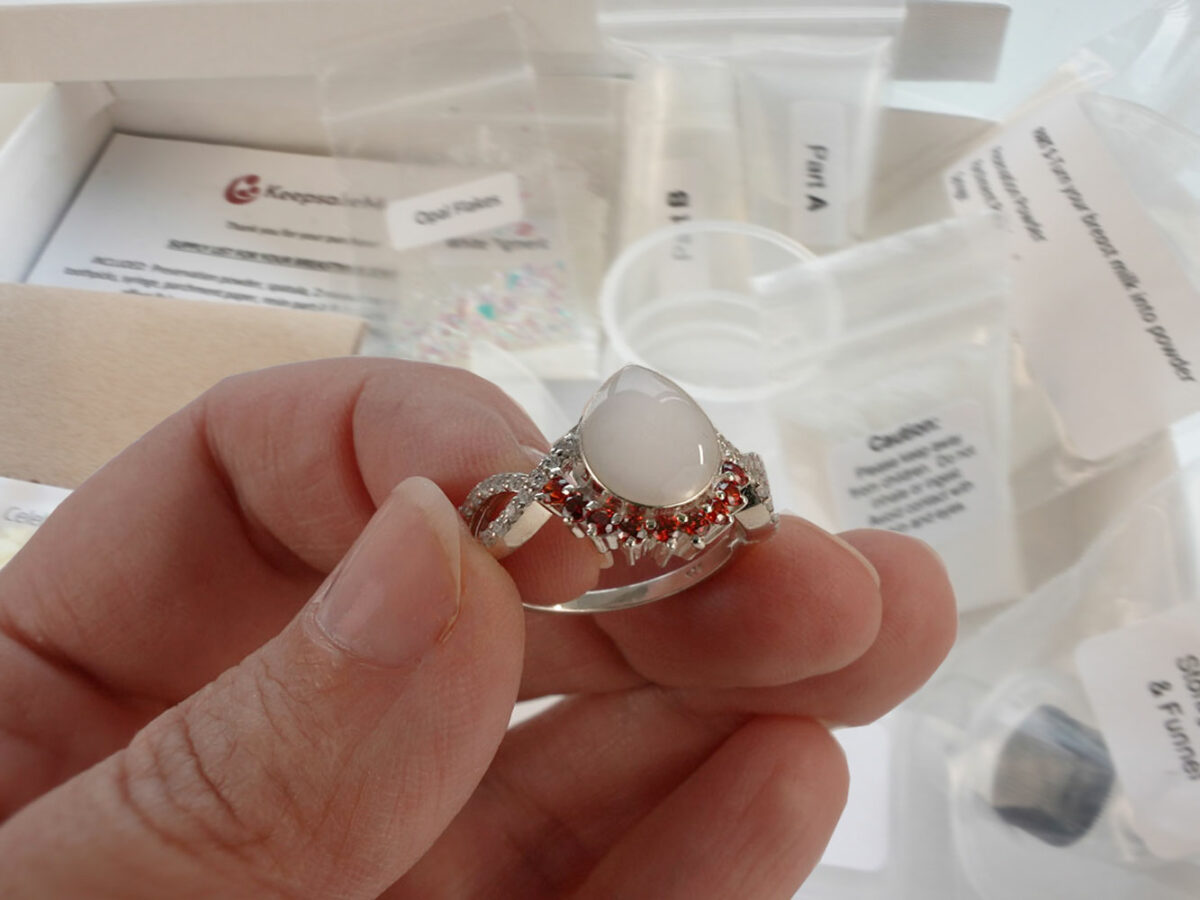 DIY kit breastmilk jewelry RING shown on a hand for DIY kit from KeepsakeMom on open diy kit box background