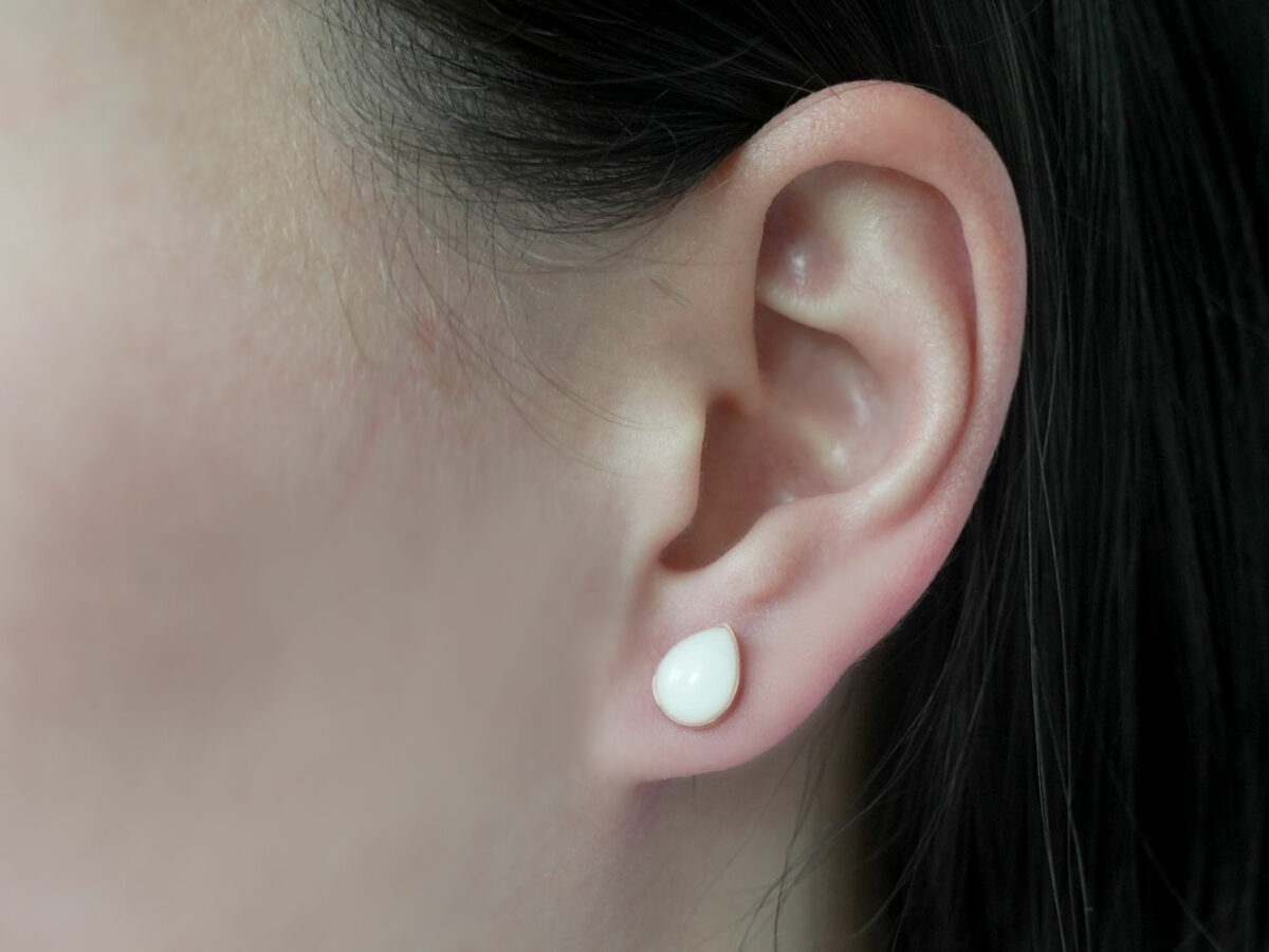 breastmilk jewelry earrings on a model ear from KeepsakeMom simple teardrop studded