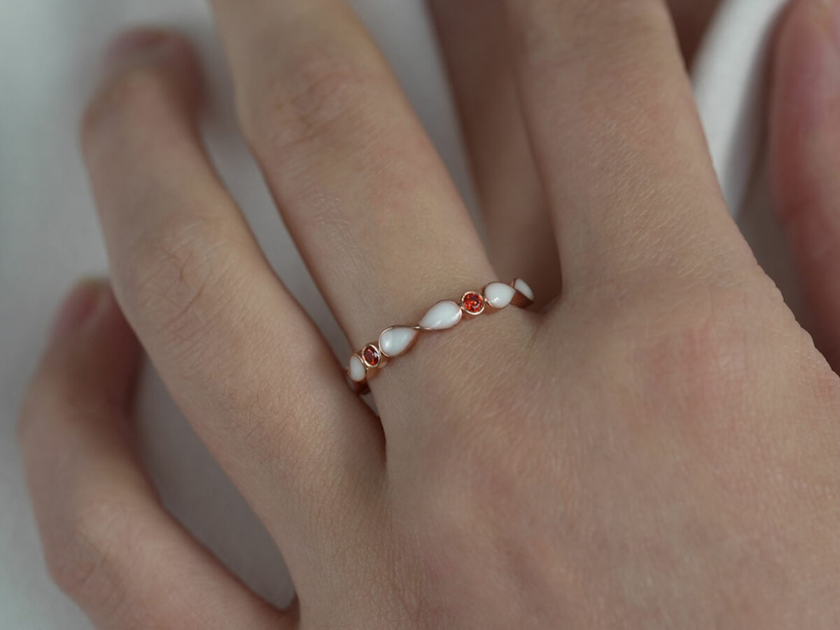 breast milk ring marquise style infinity with birth month color gems garnet red color crystals from keepsakemom gold setting on a hand model