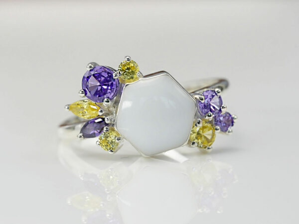 breastmilk ring in hexagon shape milk and honey with different purple and yellow birth month color crystals on each side from keepsakemom